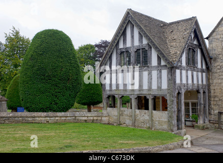 Vecchia metà-edificio con travi di legno nella motivazione di Santa Maria la Chiesa Parrocchiale in Cotswolds village di Painswick, Gloucestershire Foto Stock