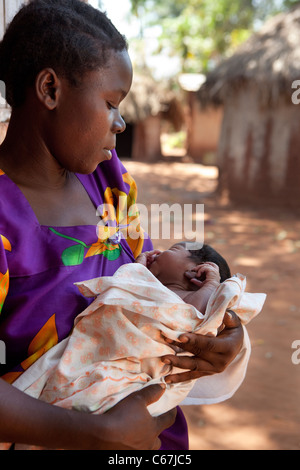 Una donna che tiene un neonato in un villaggio fuori Kamuli, Uganda, Africa orientale. Foto Stock