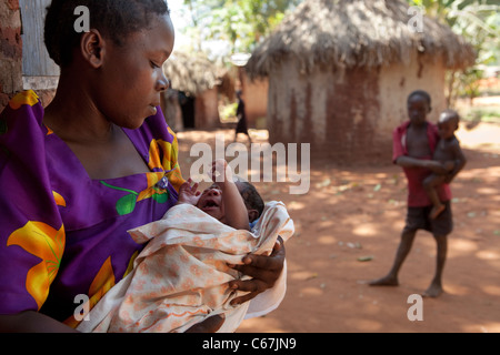 Una donna che tiene un neonato in un villaggio fuori Kamuli, Uganda, Africa orientale. Foto Stock