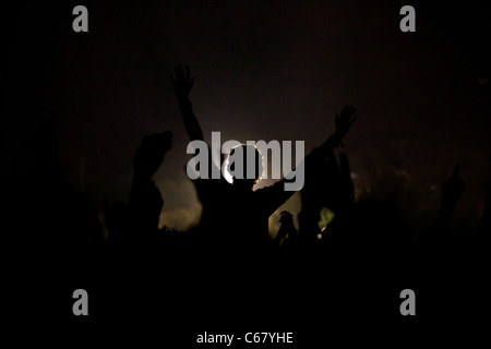 Benicassim, FIB Luglio 2011 - Festival Internazionale della Musica - Una persona che celebra il festival contro una sorgente di luce Foto Stock