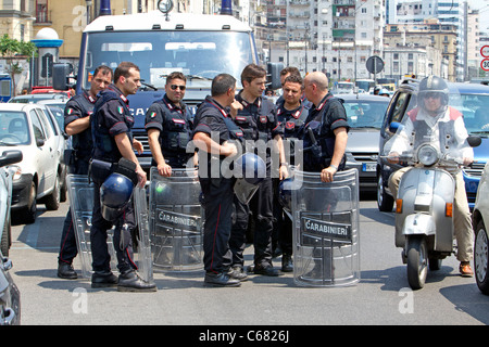 I funzionari di polizia con riot marcia alla grande protesta di occupazione sulla strada di Napoli Italia. Abbigliamento protettivo con traffico pesante. Foto Stock