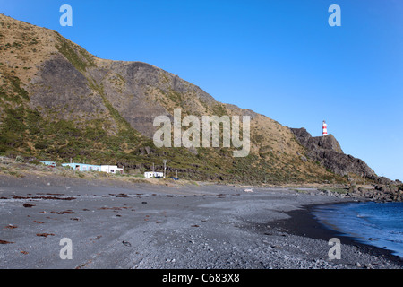 Palliser Bay il faro e la spiaggia baches (cottage). Ngawi, Palliser Bay, Wairarapa, Isola del nord, Nuova Zelanda, Australasia Foto Stock