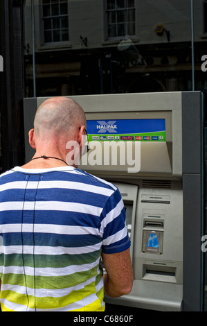 Uomo che utilizza Halifax (HBoS) cash dispenser Foto Stock