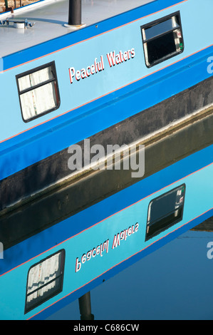 Acque tranquille Narrowboat e la sua riflessione in acqua ancora Foto Stock