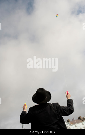 Uomo ebraico volare un aquilone: ortodosso Nigun ebrei nel periodo delle vacanze estive a Aberystwyth Wales UK Foto Stock