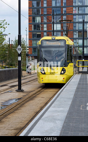 Uno dei moderni tram giallo in piedi in una piattaforma a MediaCityUK stazione in Salford Quays (parte della Metrolink system) Foto Stock