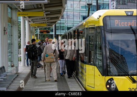 Uno dei moderni tram giallo in piedi in una piattaforma a MediaCityUK stazione in Salford Quays (parte della Metrolink system) Foto Stock