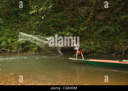 Iban uomo getta la sua rete da pesca in Batang Ai National Park in Sarawak, Borneo Malaysia Foto Stock