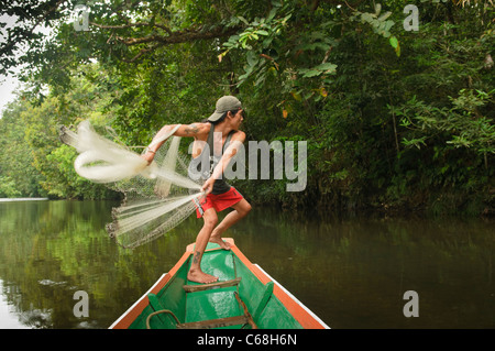 Iban uomo getta la sua rete da pesca in Batang Ai National Park in Sarawak, Borneo Malaysia Foto Stock