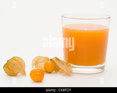 Ein Glas Multivitaminsaft, daneben liegen Physalis-Früchte | un bicchiere di multi-vitamina succo oltre sono frutti physalis Foto Stock