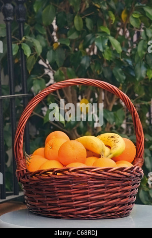 Cesto di arance e banane sul tavolo Foto Stock