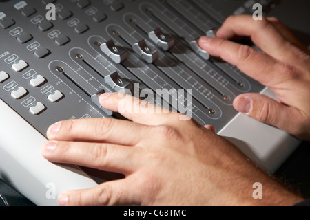 Tecnici del suono mani lavorando su una console di mixaggio in uno studio di registrazione Foto Stock