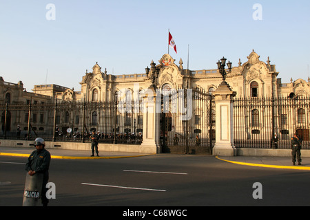 La polizia guardia come il sole pomeridiano imposta sulla Casa de Gobierno nella Plaza de Armas Foto Stock
