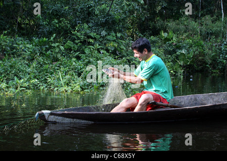 Fisherman nel controllo della sua rete sul Rio Samiria nella giungla amazzonica, lagune, Loreto, Perù, Sud America Foto Stock