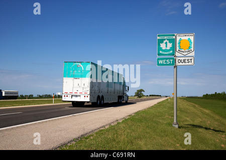 Semi rimorchio passa la segnaletica per la Trans Canada highway 1 e percorso yellowhead in Manitoba Canada Foto Stock