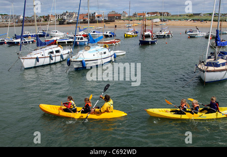 Per bambini Attività vacanze gara kayak intorno al porto di Elie un scozzese resort costiero di Fife Scozia UK Foto Stock