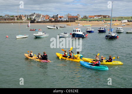 Per bambini Attività vacanze gara kayak intorno al porto di Elie un scozzese resort costiero di Fife Scozia UK Foto Stock