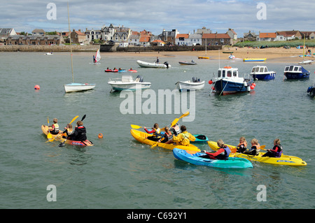 Per bambini Attività vacanze gara kayak intorno al porto di Elie un scozzese resort costiero di Fife Scozia UK Foto Stock