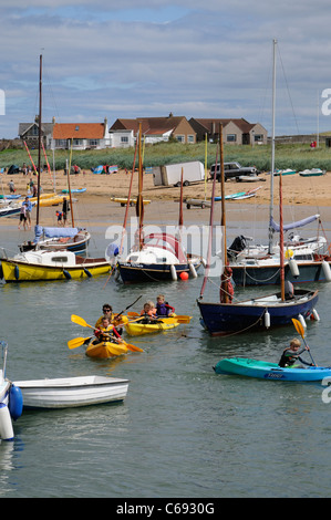 Per bambini Attività vacanze gara kayak intorno al porto di Elie un scozzese resort costiero di Fife Scozia UK Foto Stock