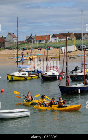 Per bambini Attività vacanze gara kayak intorno al porto di Elie un scozzese resort costiero di Fife Scozia UK Foto Stock