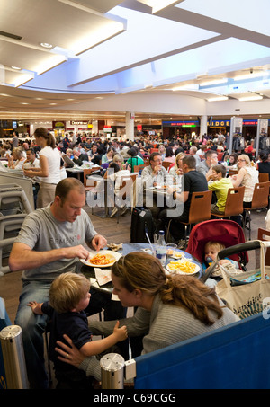 Una folla di persone in attesa nella sala partenze, terminale 3, aeroporto di Heathrow London REGNO UNITO Foto Stock