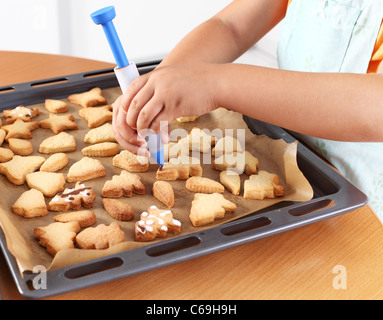 Dettaglio del bambino con le mani in mano la decorazione di cookie Foto Stock