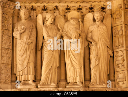 Parigi - Statua santa dal portale laterale della cattedrale di Notre Dame di notte Foto Stock