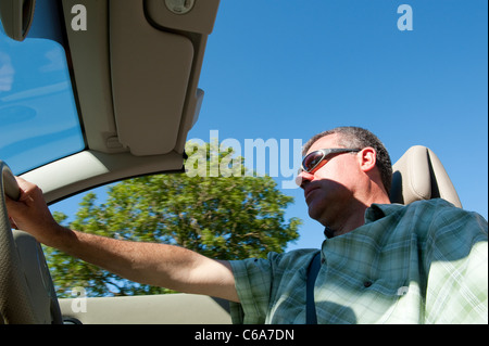 Uomo alla guida di una Renault Megane coupé cabriolet con il tetto verso il basso in estate. Foto Stock