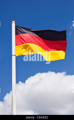 Colorata bandiera tedesca contro un cielo blu Foto Stock