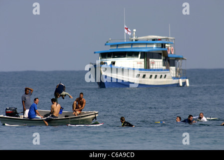 Surf ospiti da un surf barca a noleggio per preparare a navigare nelle isole mentawai, Sumatra, Indonesia. Foto Stock