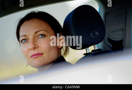 Un giovane imprenditrice sat in un auto, close up con testa resto, REGNO UNITO Foto Stock