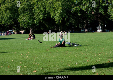 Persone in appoggio in London Fields Park, Hackney, Londra, Regno Unito Foto Stock