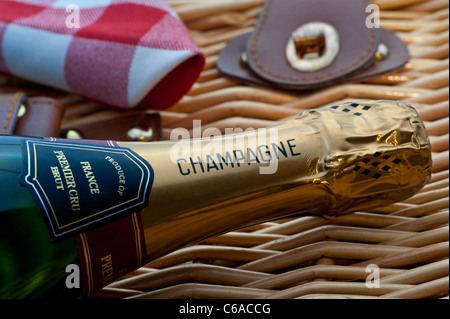 Chiudere la vista sulla bottiglia di champagne in vimini cesto da picnic a luxury alfresco evento estivo situazione picnic Foto Stock