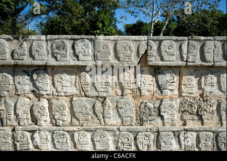 Teschi scolpiti nella roccia vicino al campo a sfera a Chichen Itza Foto Stock