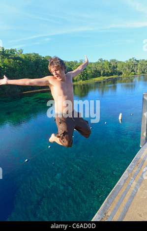 Giovane uomo salti in Wakulla molla dalla piattaforma alta Foto Stock