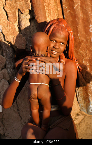 Ragazza Himba con il bambino in un villaggio vicino a Opuwo, Namibia Foto Stock