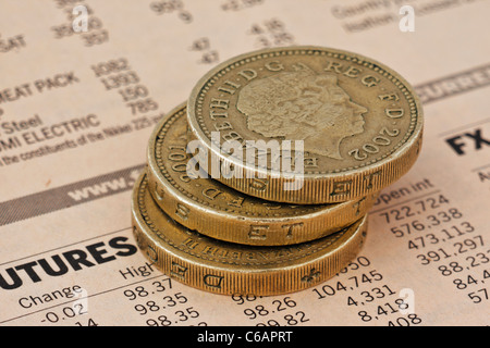 Close up libre tre monete in una pila di una pagina dal Financial Times Foto Stock
