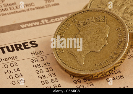 In prossimità dei due UK pound monete su una pagina di un quotidiano finanziario Foto Stock