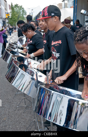 Membro della band da acciaio Metronomes orchestra che suona tamburo di acciaio a Notting Hill Campionati del panorama Foto Stock