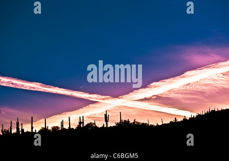 Un tramonto con due contrails facendo una X. Foto Stock