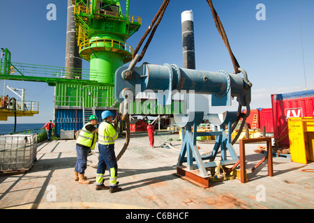 Lavoratori su un jack up barge lavorando sul Walney offshore wind farm, preparare per sollevare un pezzo di transizione in posizione. Foto Stock