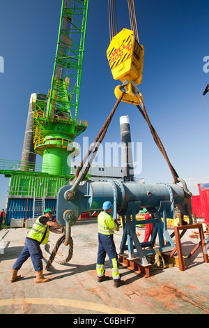 Lavoratori su un jack up barge lavorando sul Walney offshore wind farm, preparare per sollevare un pezzo di transizione in posizione. Foto Stock