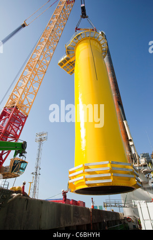 Una gru solleva un pezzo di transizione sul ponte di una chiatta, pronto per estrarre il Walney offshore wind farm Foto Stock