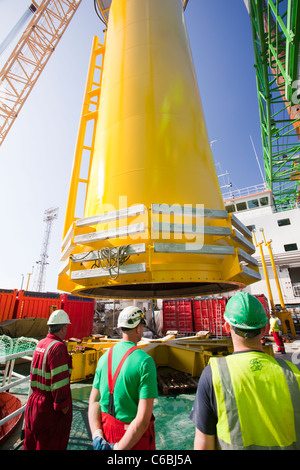 Una gru solleva un pezzo di transizione sul ponte di una chiatta, pronto per estrarre il Walney offshore wind farm Foto Stock