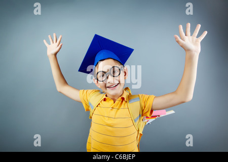 Ritratto di felice schoolkid zaino con bracci di sollevamento Foto Stock