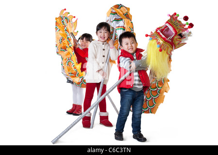 Tre bambini cinesi holding draghi cinesi Foto Stock