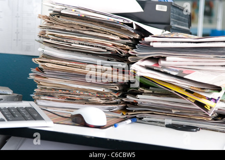 Cumulo di quotidiani e il disordine sulla scrivania del giornalista Foto Stock
