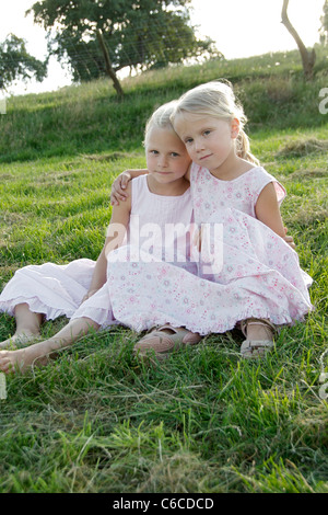 Ritratto di due amiche di mettere le loro braccia attorno alle loro spalle in estate, Eyendorf, Bassa Sassonia, Germania, Europa Foto Stock