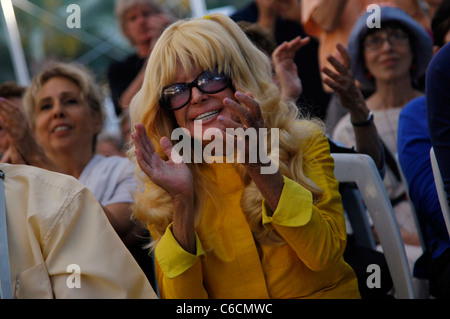 La "donna in giallo", Bat Sheva Israel-Levi reagisce mentre siede con un gruppo di destri, coloni e religiosi che guardano la personalità radiofonica statunitense Glenn Beck in diretta sullo schermo in Piazza Safra, di fronte al Municipio di Gerusalemme Israele Foto Stock