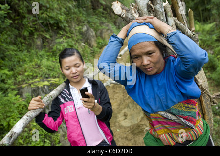 Bui Thi Tinh e sua figlia Ngan Thi Su camminare indietro home dopo il taglio di legna da ardere nella giungla intorno al divieto figlio in Vietnam del Nord Foto Stock